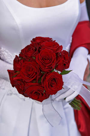 bride holding beautiful red rose wedding beauquetの写真素材