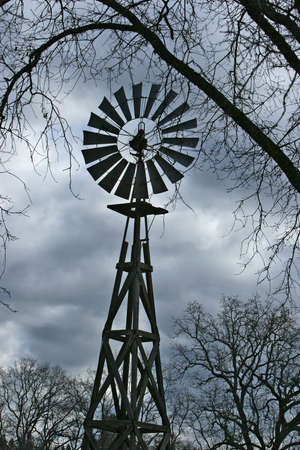 Close up of a windmill surrounded by treesの写真素材