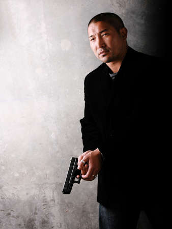 Asian Man Holding a Gunの写真素材