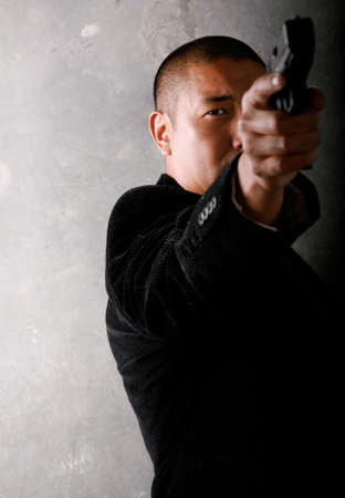 Asian Man Pointing a Gunの写真素材