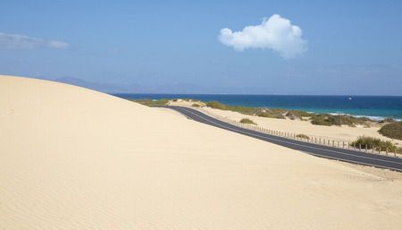 Sand dunes in Corralejo National Park and view of sea and road, Fuerteventura, Canary Islands, Spainの写真素材