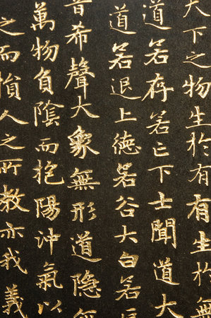 Golden chinese calligraphy in a black backgroundの写真素材