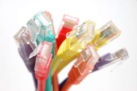 Close up of multi color network cable plugs over white