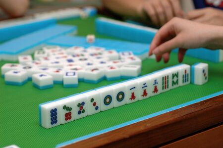 People playing mahjong on a tableの写真素材