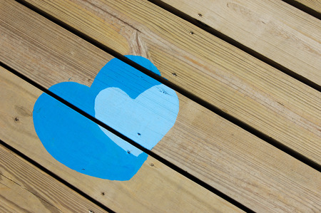 Background of painted blue hearts on wooden floorの写真素材