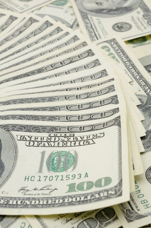 Fanned out US one hundred dollar bills, focus on the 100