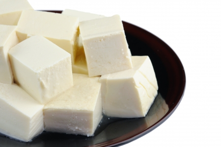 Close up of tofu on plate over whiteの写真素材