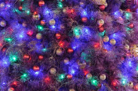 Christmas ornaments on tree in colorful lightingの写真素材