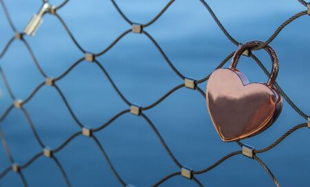 pink heart shaped lock near to the oceanの写真素材