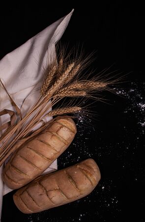 homemade white bread surrounded by flour and wheatの写真素材