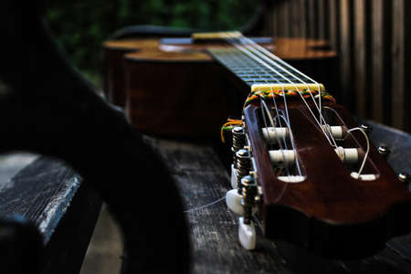 an acoustic guitar on a brown benchの写真素材