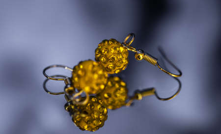 beautiful yellow earrings on a blue backgroundの写真素材