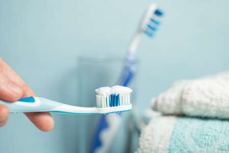 Young woman holding a blue toothbrush. Woman brushing her tooths. Health concept.の写真素材