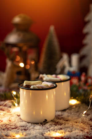 Hot chocolates surrounded with christmas decorations. Sweet hot chocolates with marshmallow. Christmas concept.の写真素材