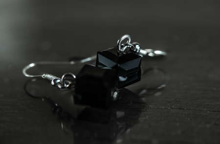 Little black earrings on a black background. Earrings for woman.の写真素材