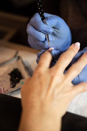 Closeup shot of a woman in a nail salon receiving a manicure by a butician.の写真素材