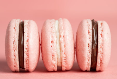 Three pink macaron on a pink background. French dessert.の写真素材