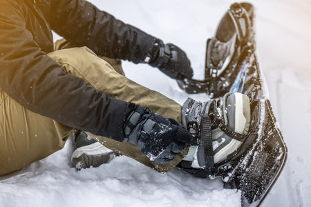 Young girl snowboarder tieing up her snowboard