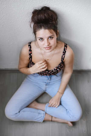 Cute, young girl sitting on the floor. Girl smiling.の写真素材