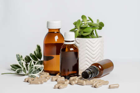 Alternative herbal medicine. Vitamine capsules and oils on a white background.の写真素材