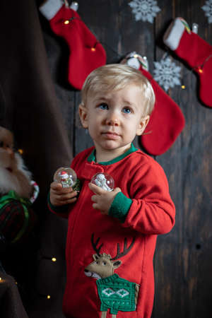 Cute, blonde baby boy playing with snowglobes. Baby's first Christmas.の写真素材
