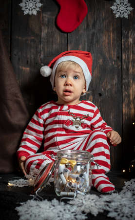 Baby's first Christmas. Cute baby boy surrounded with Christmas decorations.の写真素材