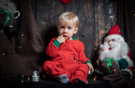 Baby's first Christmas. Cute baby boy surrounded with Christmas decorations.の写真素材