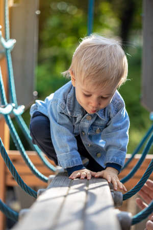 Little blond haired boy playing on the playground. Happy boy.の写真素材