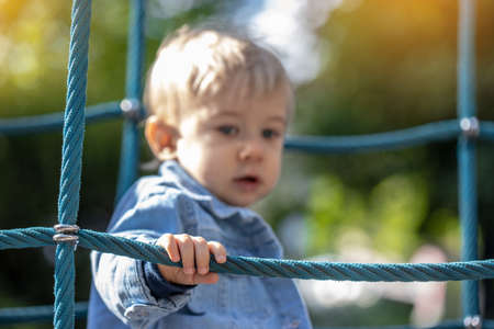 Little blond haired boy playing on the playground. Happy boy.の写真素材