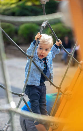 Little blond haired boy playing on the playground. Happy boy.の写真素材