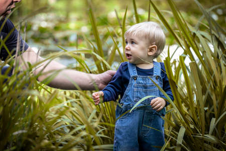 Little blond haired boy standing in the nature and laughing.の写真素材