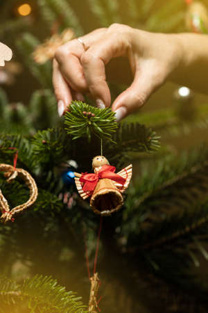Decorated Christmas tree on blurred background. Woman decorating the tree.の写真素材