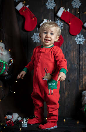 Baby's first Christmas. Cute baby boy surrounded with Christmas decorations.の写真素材