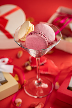 Valentine macarons, gift box and red ribbon on a red background.の写真素材