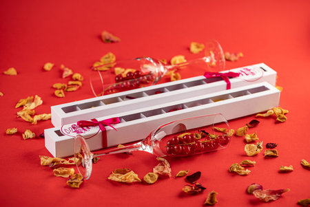 Valentine chocolate candies, gift box and red ribbon on a red background.の写真素材