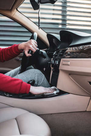 Young boy cleaning his car. A boy taking care of his vehicle.の写真素材