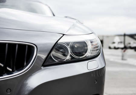 Close up of a headlight. Headlight of a white car.の写真素材