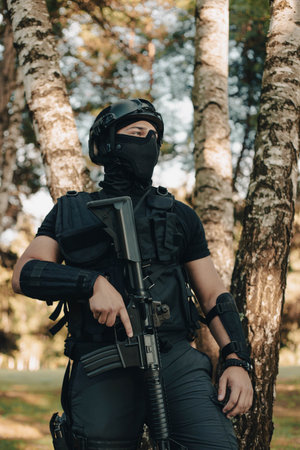 Airsoft soldier in the woods. Soldier looking for something. Young man.