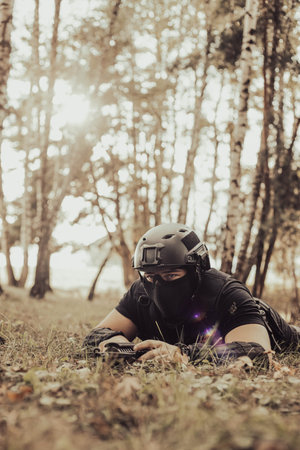 Airsoft soldier in the woods. Soldier looking for something. Young man.の写真素材