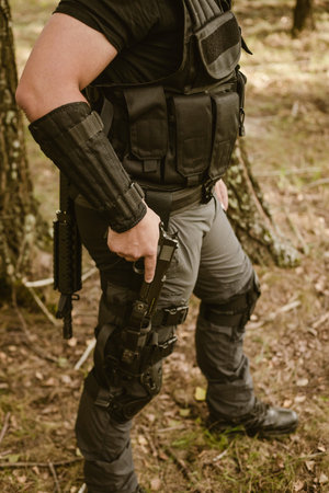 Airsoft soldier in the woods. Soldier looking for something. Young man.の写真素材