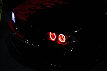 Close up of a headlight. Headight of a black car. red headlight.の写真素材