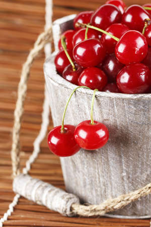 Fresh cherries with water drops in a wood bucketの写真素材