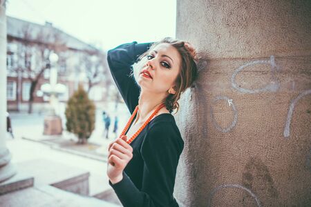 Young pretty sexy lady in black dress outdoor near old building with red lipsの写真素材