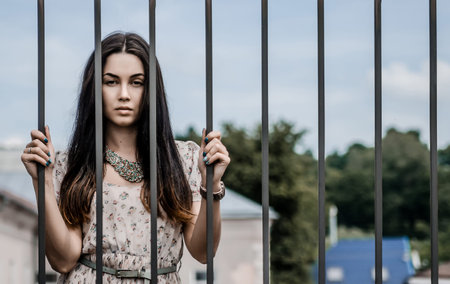 Girl in the old castle, staying behind gatesの写真素材