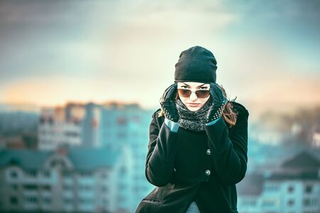 Girl in the sunglasses on the roof of high buildingの写真素材