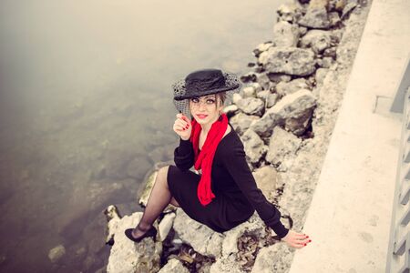 Young pretty sexy lady in black dress outdoor with ice on the lake on backgroundの写真素材