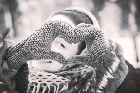 Pretty girl with heart shaped hands is the gloves outdoorの写真素材