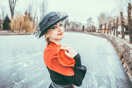 Young pretty sexy lady in black dress outdoor with ice on the lake on backgroundの写真素材