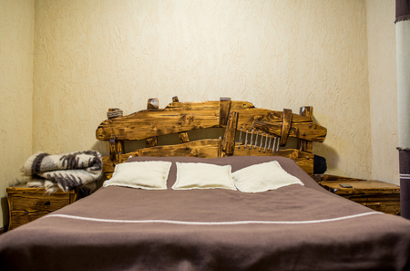 Handmade wooden bed in the roomの写真素材