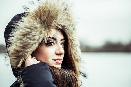 Young pretty girl with forest and lake on backgroundの写真素材